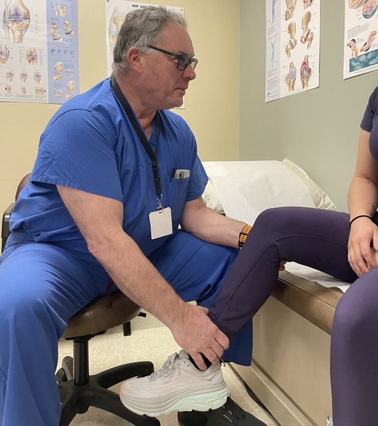 Orthopedic surgeon, Dr. Gluscic checking patient knee
